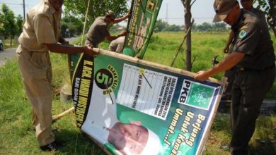 Satpol PP Ambon Turunkan Baliho Paslon Yang Tak Kenakan Masker